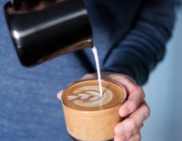 Image of milk being poured into a coffee.